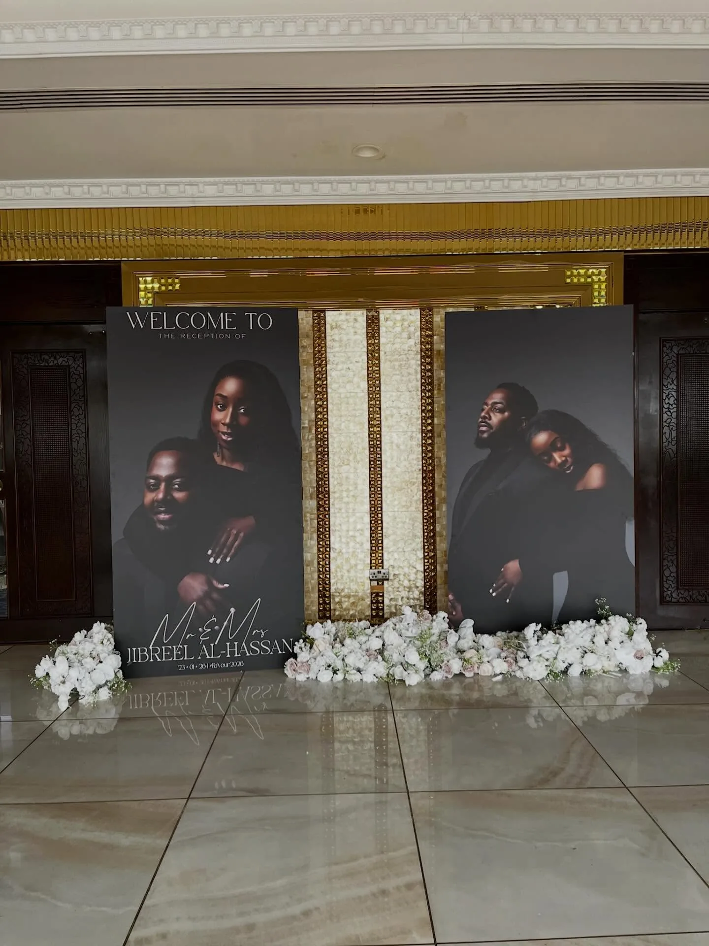 Two 8ft standing boards with portraits of Mr and Mrs Jibreel Al-Hassan in a reception hall