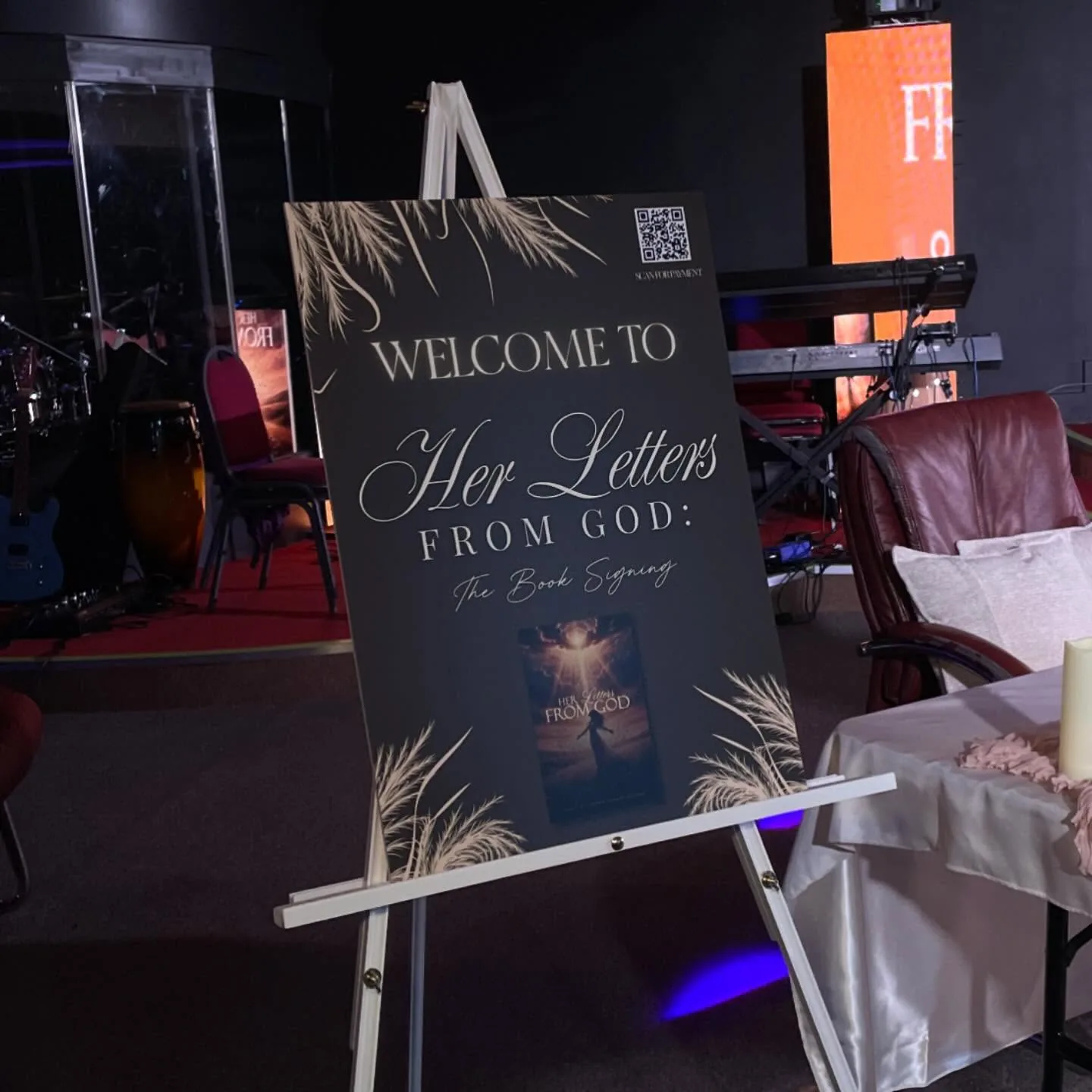 Dark welcome board for the book signing of Her Letters from God, on an easel